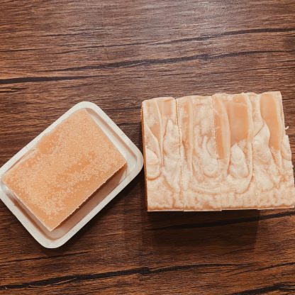 natural colored bars of goat milk soap on rustic wood background.