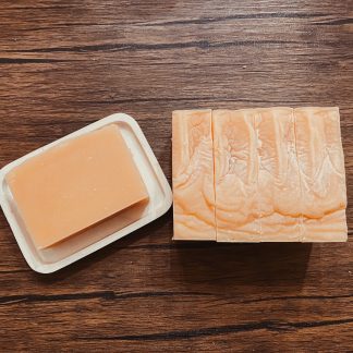 natural color bars of goat milk soap on rustic wood background.